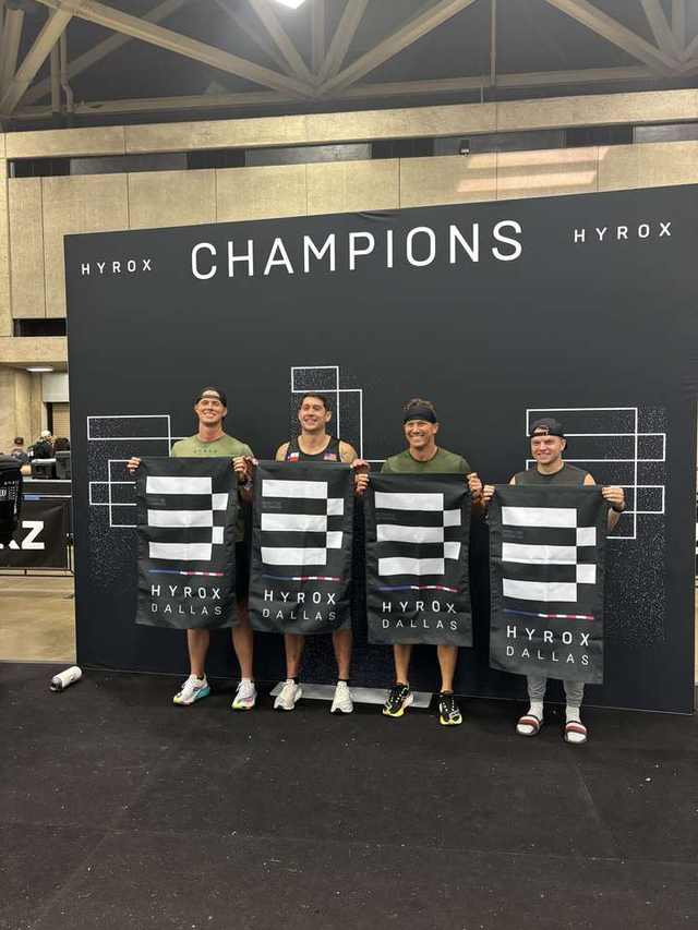 FTX men's relay champions at HYROX Dallas holding winner banners