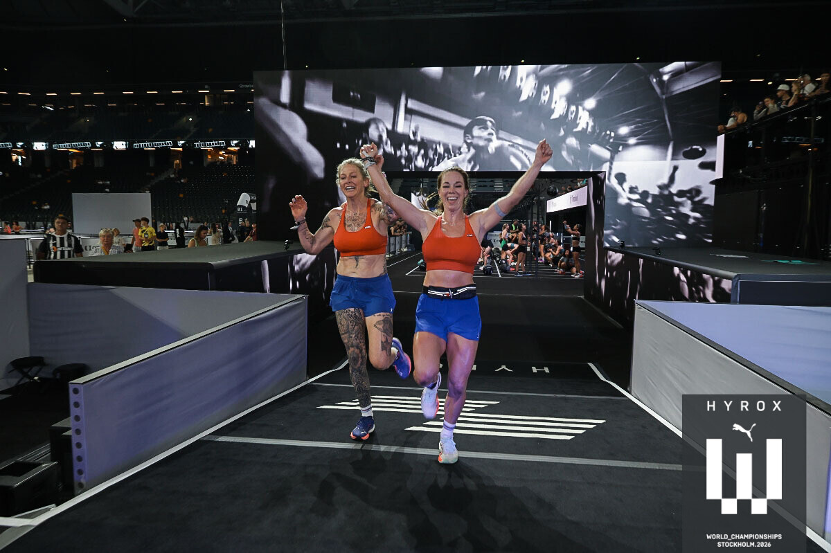 Dos atletas de ATHENA cruzando la meta juntas en el Campeonato Mundial HYROX, Estocolmo 2026
