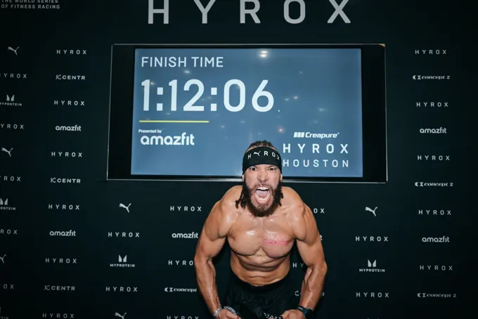 FTX athlete celebrating in front of the HYROX Houston finish board