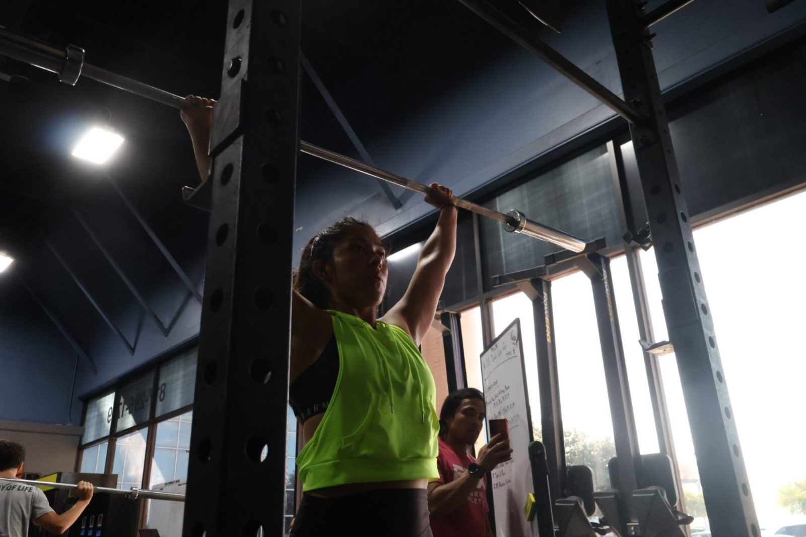 Overhead barbell work during a coached class at FTX Fort Worth
