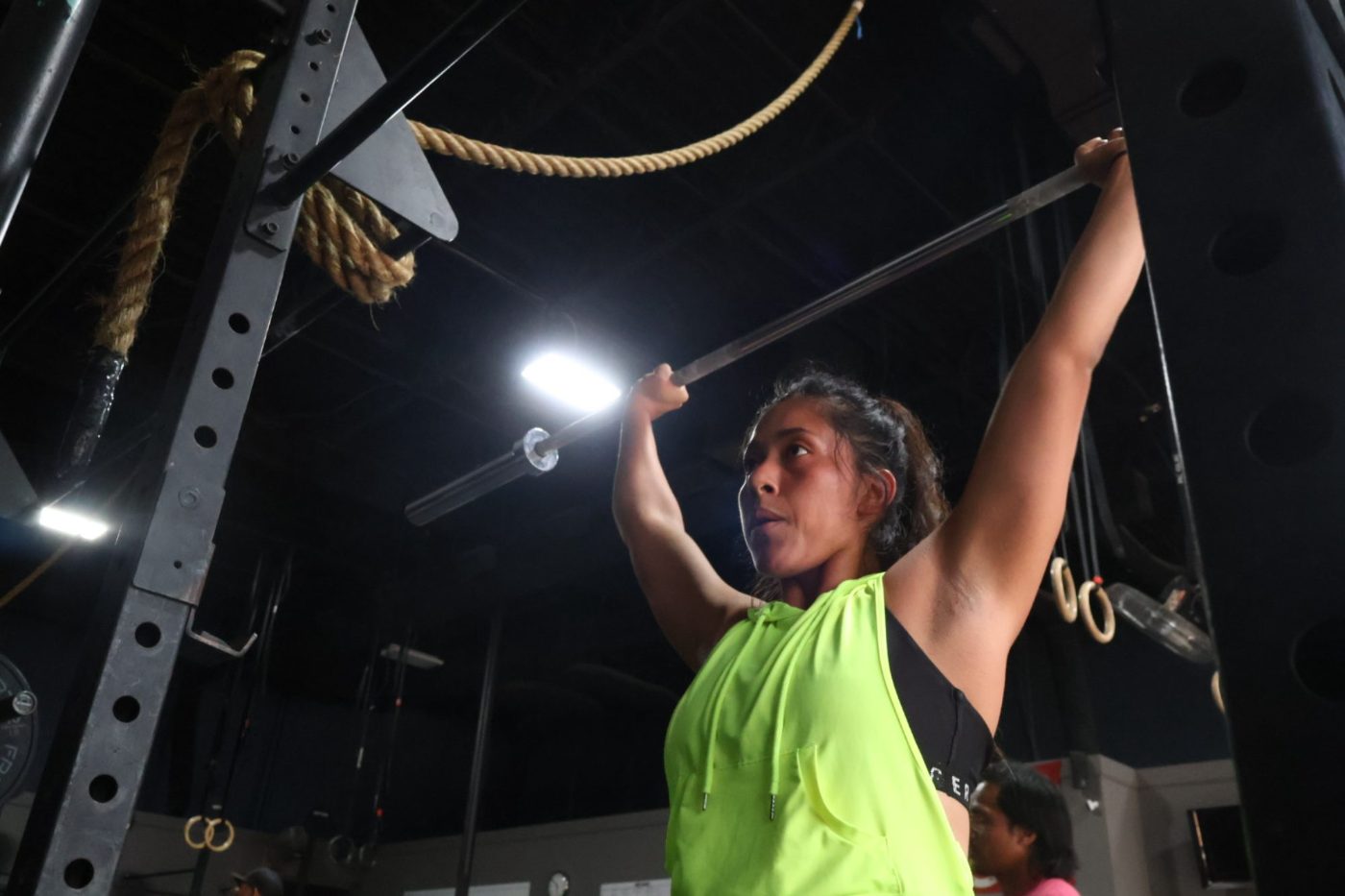 A member pressing overhead in a strength session at FTX Fort Worth